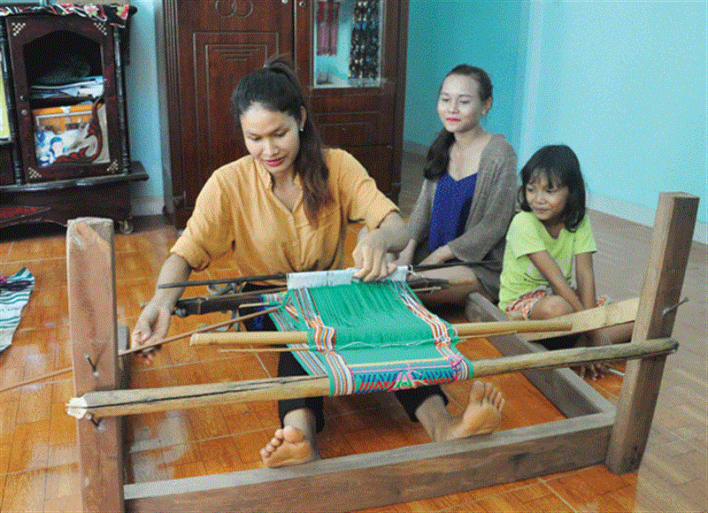 Chị Ka Hoàn đang truyền nghề dệt thổ cẩm cho người thân. Ảnh: V.T
